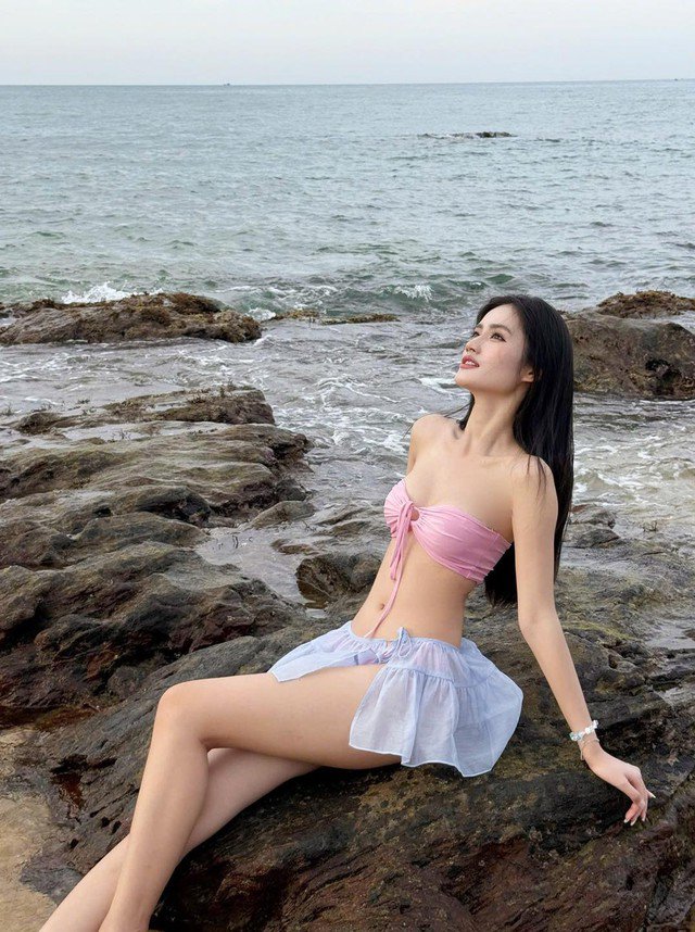 Nàng hậu diện trên mình bộ bikini hồng pastel nhẹ nhàng kết hợp cùng chân váy xuyên thấu, sự phối hợp táo bạo nhưng tinh tế, làm nổi bật vẻ nữ tính nhưng vẫn giữ được nét thanh lịch, hiện đại.